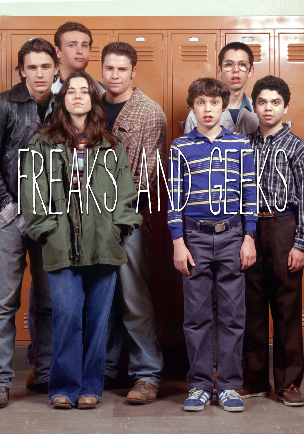 A poster of 7 teenagers in front of lockers. Four on the left are social rejects. Three on the right are dweebs. Across the image it says "Freaks and Geeks." Am image from a short-lived 1999 television show.