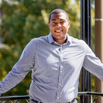 Image of Richard Newton on a balcony in front of trees.