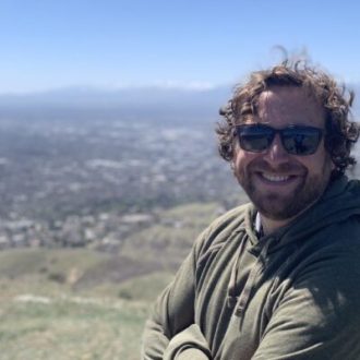 Jeffrey Turner is wearing sunglasses with a desert in the background.