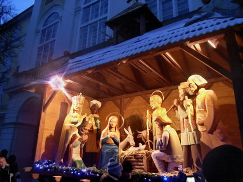A nativity scene made of giant wooden figures on a street in Ukraine.